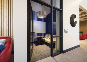 a living room with a red couch and a glass door